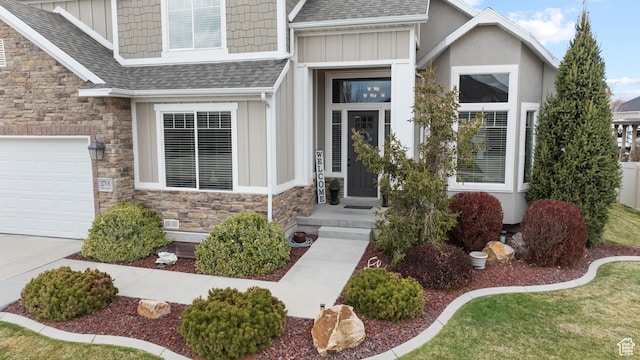 property entrance with stone siding, a shingled roof, board and batten siding, and a garage