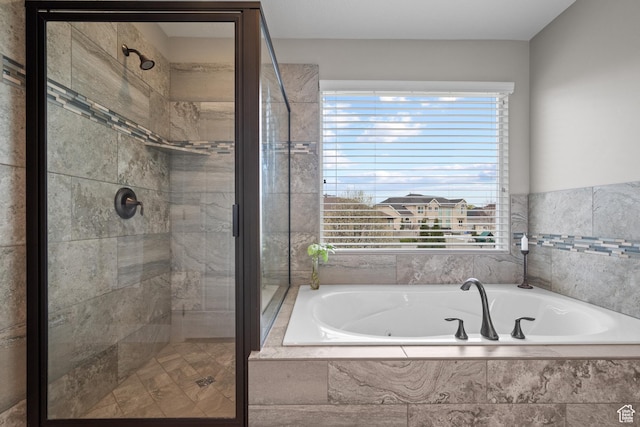 bathroom with a shower stall and a bath