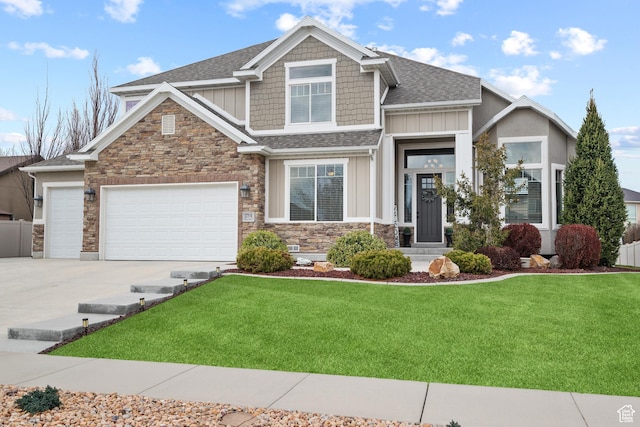 craftsman-style home with driveway, board and batten siding, a front yard, stone siding, and roof with shingles