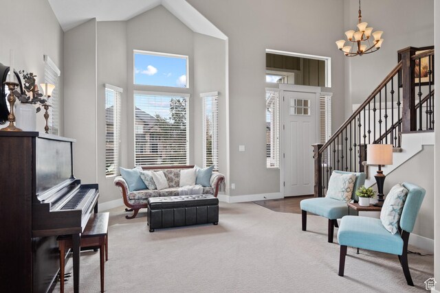 carpeted living room featuring an inviting chandelier, baseboards, and high vaulted ceiling