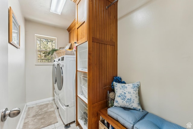 laundry room featuring washer and clothes dryer, cabinet space, baseboards, and light tile patterned floors