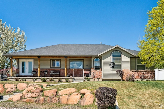back of house with covered porch, a yard, and french doors