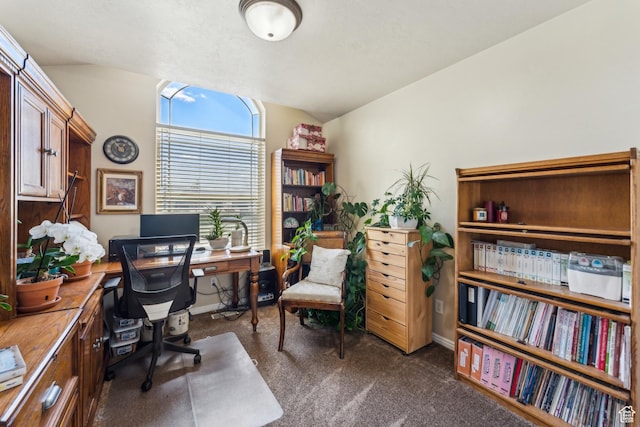 office area featuring lofted ceiling, baseboards, and dark colored carpet