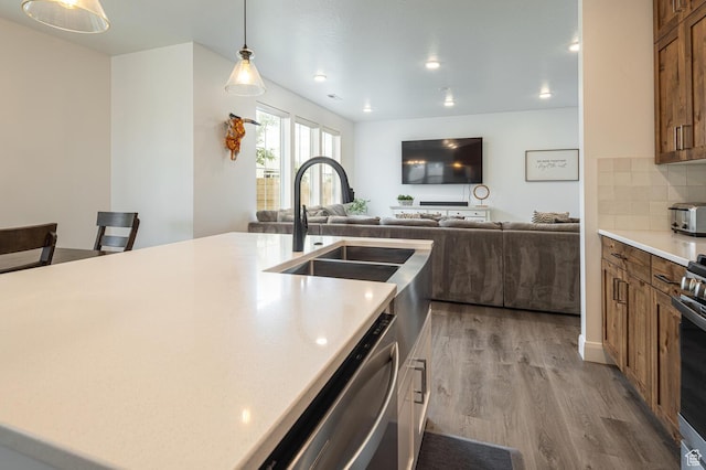 5740 Cardinal Wing Dr Unit 17, St George, UT 84790 - kitchen featuring a sink, brown cabinetry, wood finished floors, light countertops, and stainless steel dishwasher