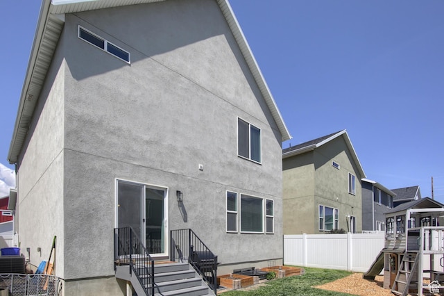 452 S Highpoint Dr, Saratoga Springs, UT 84045 - back of house featuring central AC, a playground, stucco siding, and fence