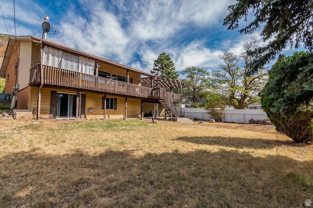 back of house with a yard, stairs, a wooden deck, and fence