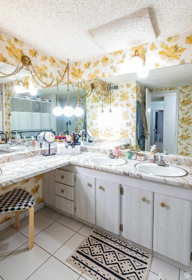 full bath featuring a sink, a textured ceiling, wallpapered walls, and visible vents
