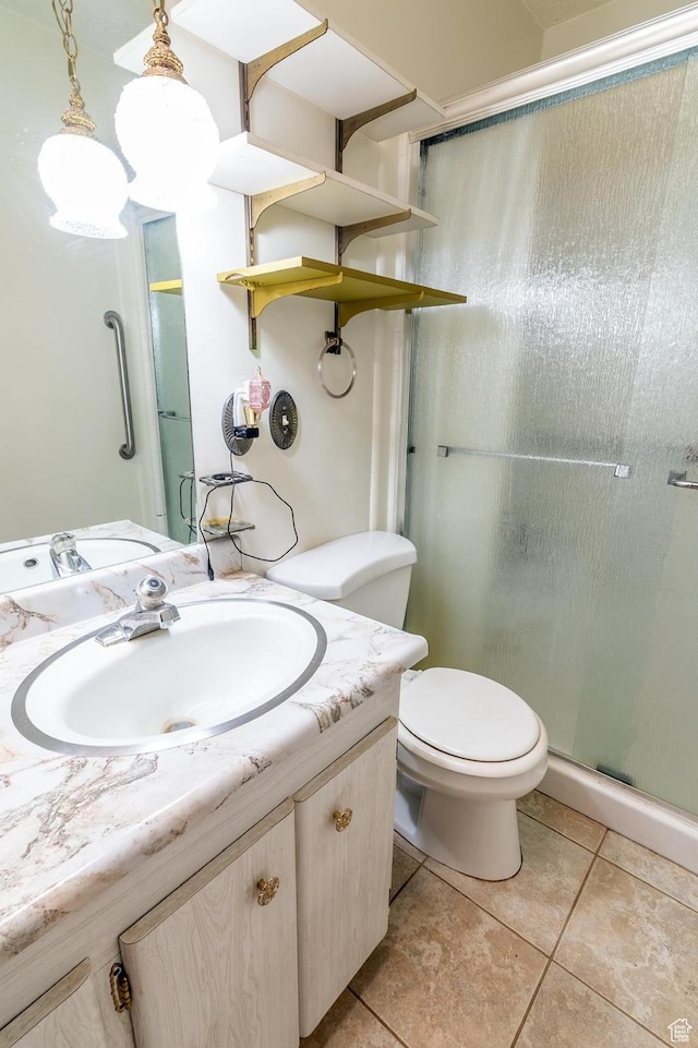 full bath featuring a stall shower, tile patterned floors, vanity, and toilet
