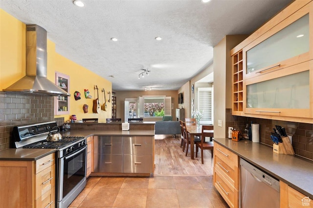 1159 S Windsor St, Salt Lake City, UT 84105 - kitchen featuring a peninsula, island exhaust hood, a textured ceiling, dark countertops, and appliances with stainless steel finishes