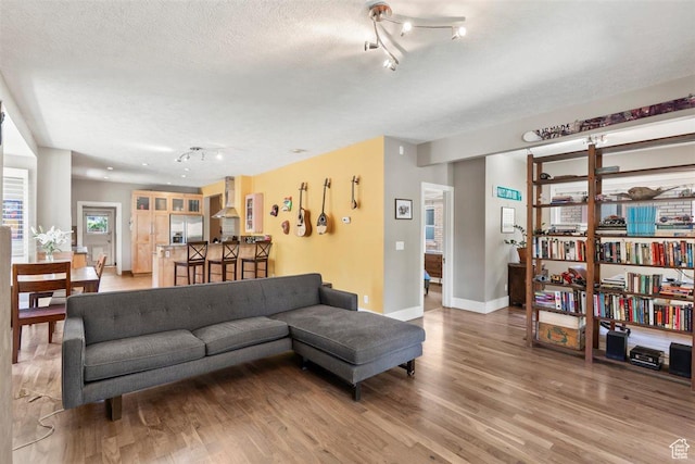 1159 S Windsor St, Salt Lake City, UT 84105 - living area featuring track lighting, light wood-type flooring, baseboards, and a textured ceiling