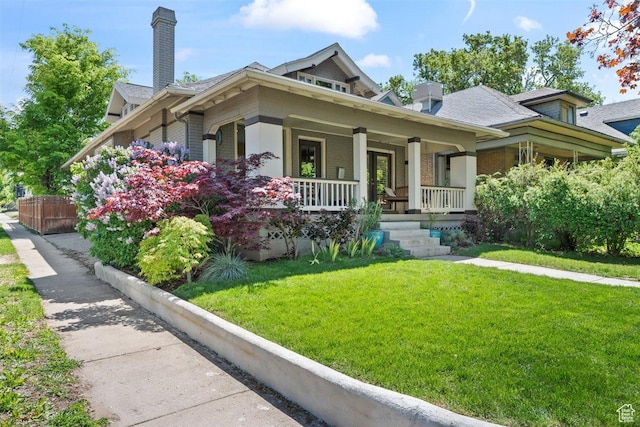 1159 S Windsor St, Salt Lake City, UT 84105 - view of front of property featuring covered porch, a chimney, fence, a front yard, and brick siding