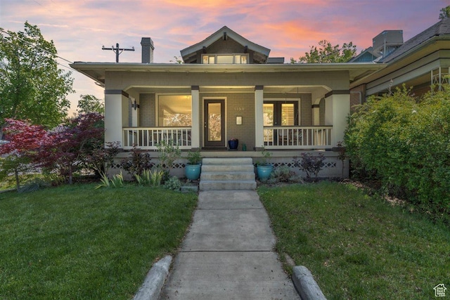 1159 S Windsor St, Salt Lake City, UT 84105 - view of front of house featuring covered porch, brick siding, a chimney, and a lawn