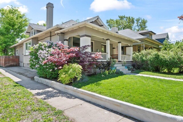 1159 S Windsor St, Salt Lake City, UT 84105 - view of front of home featuring a chimney, brick siding, fence, a porch, and a front lawn