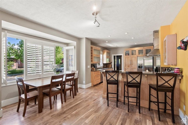 1159 S Windsor St, Salt Lake City, UT 84105 - kitchen with a peninsula, stainless steel appliances, a textured ceiling, ventilation hood, and dark countertops
