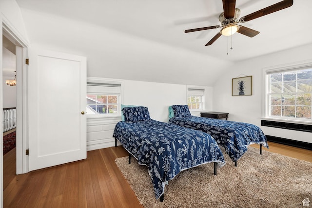 341 E E Blvd, Logan, UT 84321 - bedroom featuring radiator, wood finished floors, radiator heating unit, vaulted ceiling, and ceiling fan