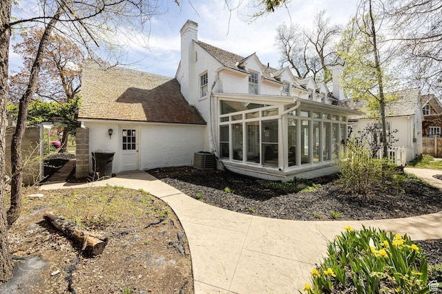 341 E E Blvd, Logan, UT 84321 - view of property exterior featuring a sunroom, roof with shingles, a chimney, and central air condition unit