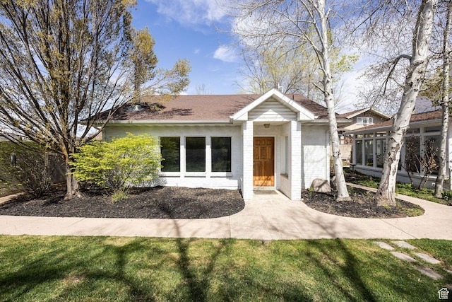 341 E E Blvd, Logan, UT 84321 - view of front facade featuring a front lawn and brick siding