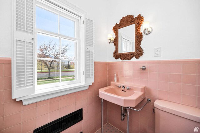 341 E E Blvd, Logan, UT 84321 - half bathroom with a wainscoted wall, tile walls, a wealth of natural light, and toilet