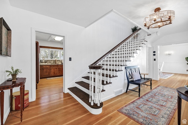 341 E E Blvd, Logan, UT 84321 - staircase featuring baseboards, a notable chandelier, visible vents, and wood finished floors