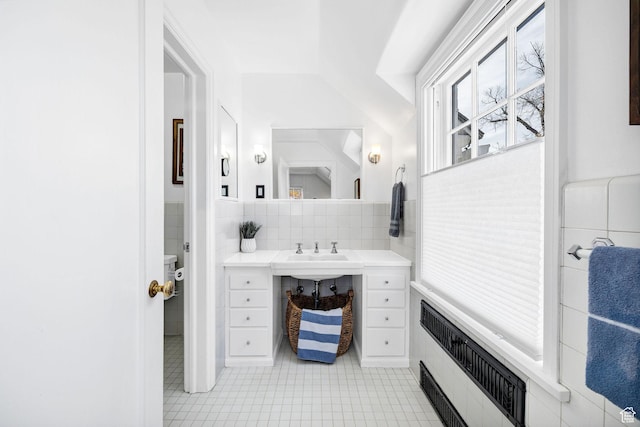 341 E E Blvd, Logan, UT 84321 - bathroom featuring tile walls, radiator, a sink, tile patterned floors, and backsplash