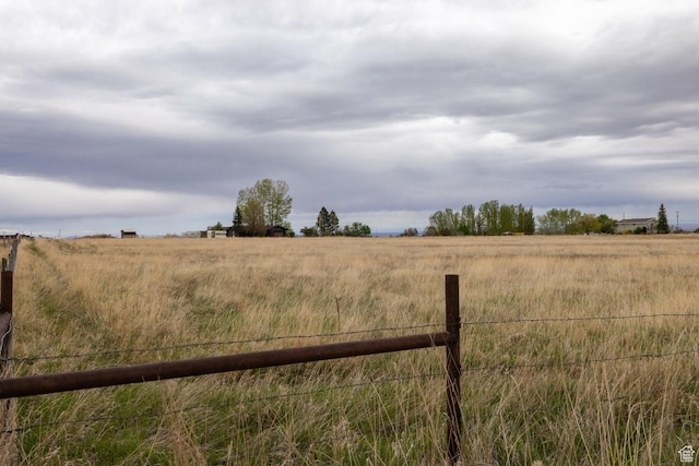 view of yard featuring fence and a view of rural / pastoral area