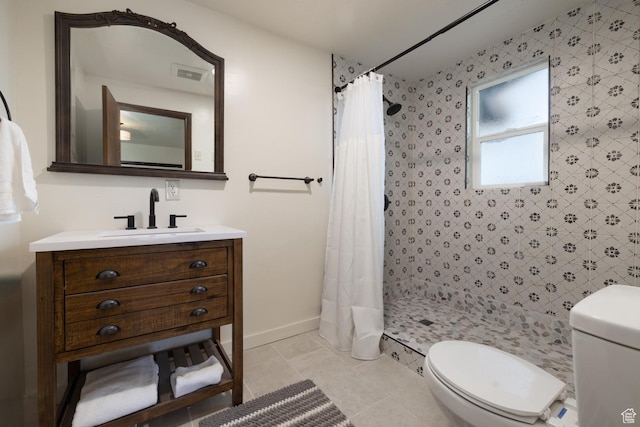 bathroom with toilet, a shower stall, vanity, and baseboards