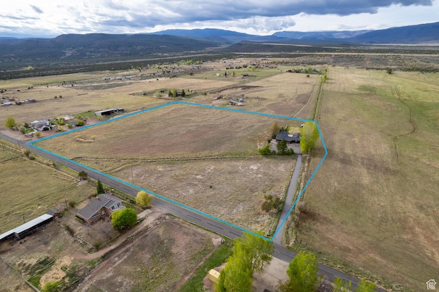 aerial view of sparsely populated area featuring a mountain backdrop and property parcel outlined