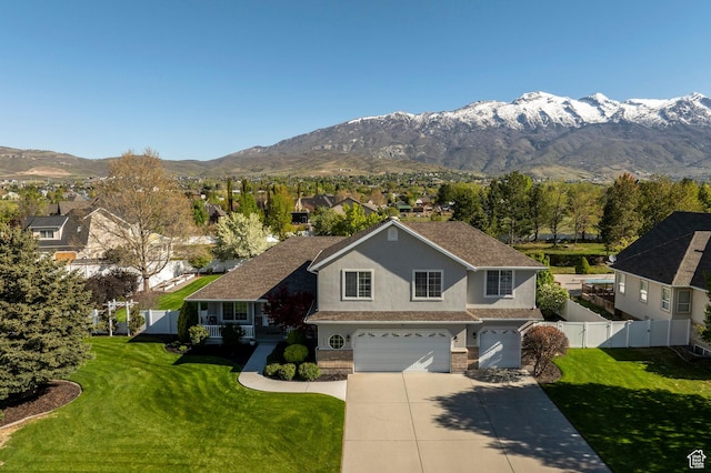 view of front of home with a mountain view, a garage, stucco siding, fence, and driveway