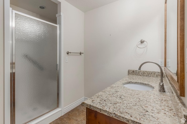 full bathroom with vanity, baseboards, and a shower stall