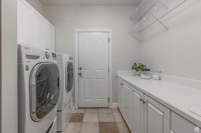 clothes washing area with cabinet space, washing machine and clothes dryer, and light tile patterned floors