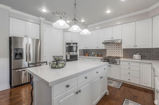 kitchen featuring dark wood-type flooring, under cabinet range hood, appliances with stainless steel finishes, a kitchen island, and ornamental molding