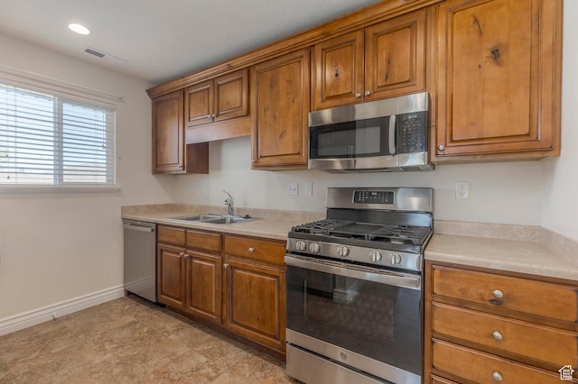 kitchen with brown cabinetry, stainless steel appliances, and visible vents