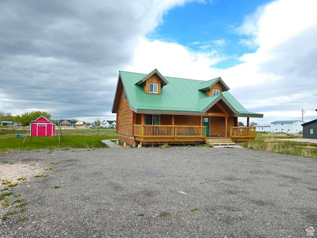 50 E 200 S, Saint Charles, ID 83272 - log-style house with a porch, metal roof, and gravel driveway