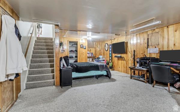 carpeted bedroom with wooden walls