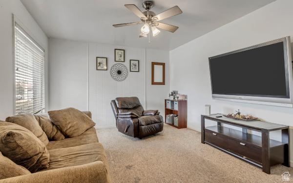 carpeted living room featuring a ceiling fan