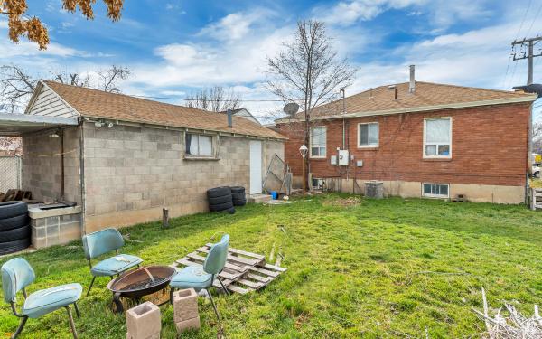 rear view of property featuring a yard and a fire pit