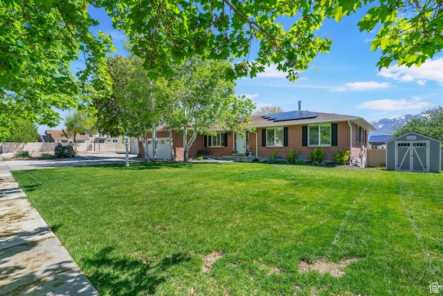 11549 S Equestrian Dr W, South Jordan, UT 84095 - ranch-style house with a storage shed, fence, brick siding, a front yard, and roof mounted solar panels