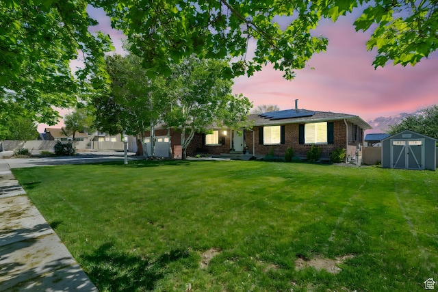 11549 S Equestrian Dr W, South Jordan, UT 84095 - ranch-style home with a storage unit, roof mounted solar panels, brick siding, and a yard