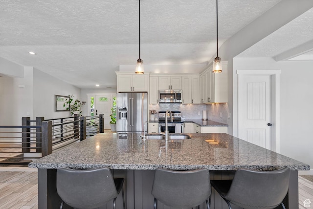 11549 S Equestrian Dr W, South Jordan, UT 84095 - kitchen with a textured ceiling, stainless steel appliances, white cabinets, and a sink