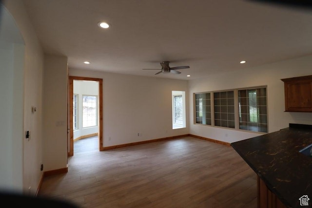 unfurnished living room featuring wood finished floors, baseboards, a ceiling fan, and recessed lighting