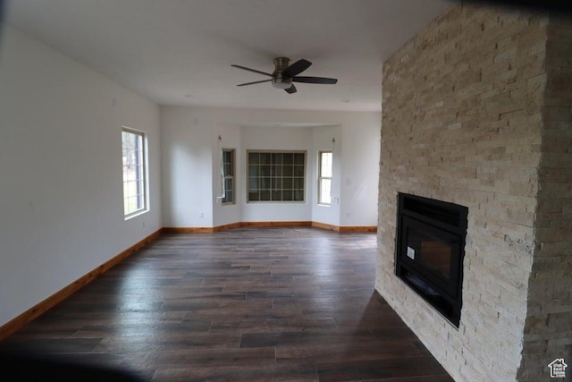 unfurnished living room featuring a fireplace, ceiling fan, baseboards, and wood finished floors