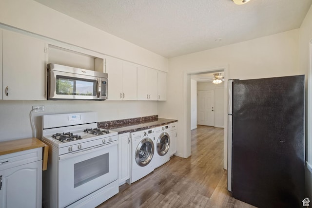 370 E Scott Ave, South Salt Lake, UT 84115 - kitchen with wood finished floors, washer and dryer, white cabinetry, a ceiling fan, and appliances with stainless steel finishes