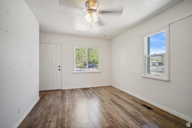 370 E Scott Ave, South Salt Lake, UT 84115 - unfurnished room with a textured ceiling, baseboards, ceiling fan, visible vents, and wood finished floors