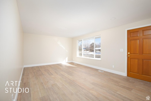 unfurnished room with baseboards, visible vents, and light wood-type flooring
