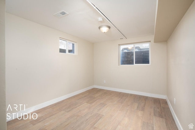 unfurnished room featuring light wood finished floors, visible vents, baseboards, and a healthy amount of sunlight