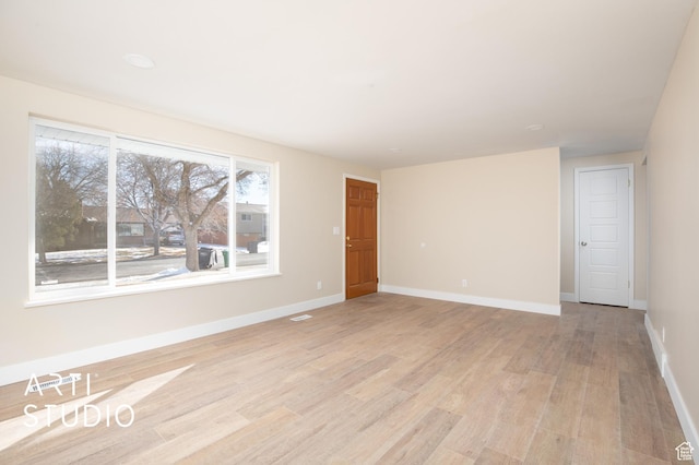 unfurnished room featuring baseboards and light wood-style flooring