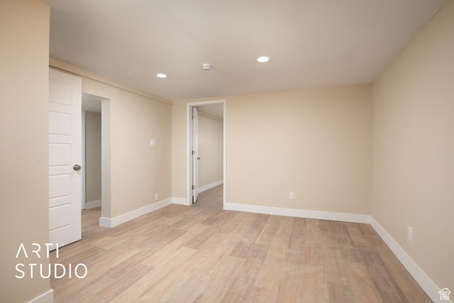 spare room with baseboards, recessed lighting, and light wood-type flooring