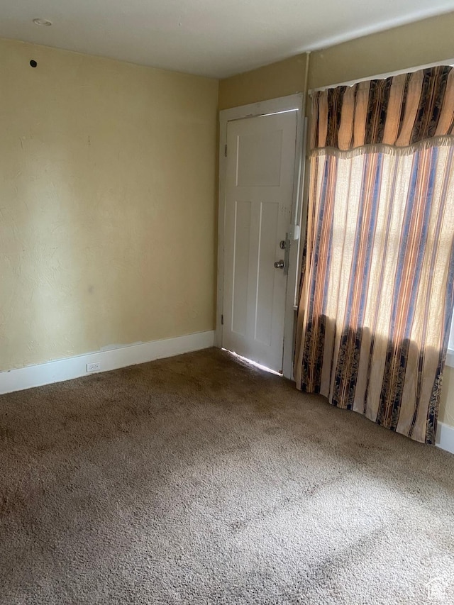 carpeted spare room with baseboards