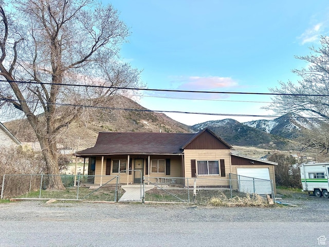 260 E Leadville Row, Eureka, UT 84628 - view of front facade featuring a porch, a fenced front yard, a garage, and a mountain view