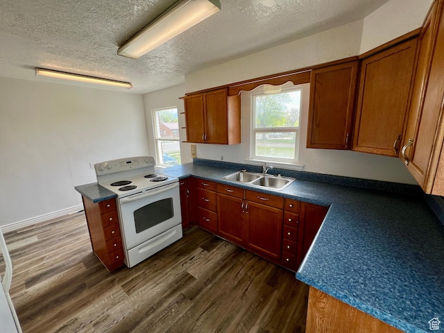 kitchen featuring white electric stove, dark countertops, and dark wood finished floors